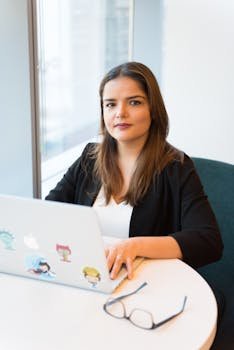 Woman in Black Coat Browsing on Laptop Computer